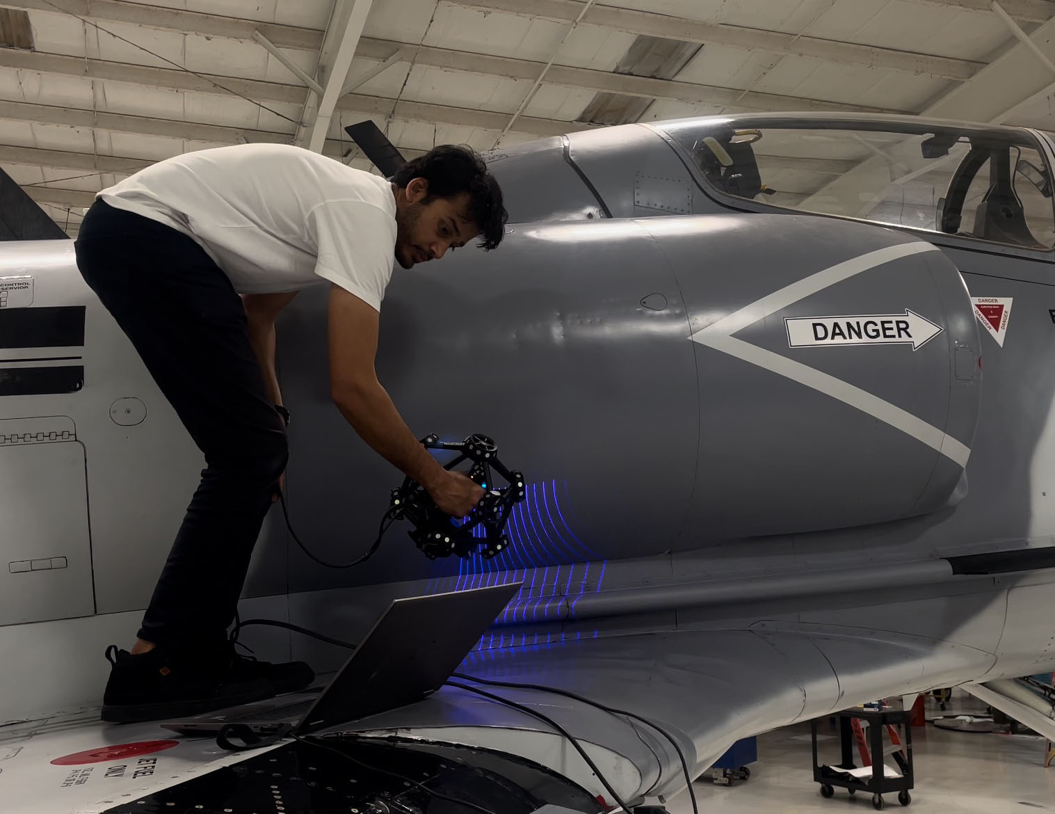 Technician capturing exact geometry of a jet aircraft with a handheld scanner